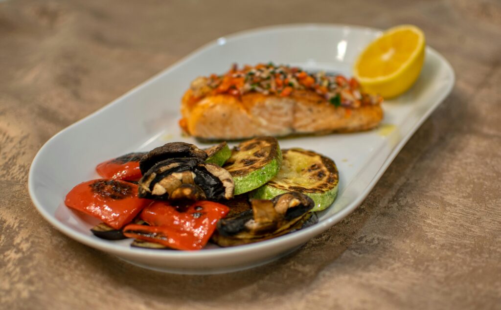 Baked salmon on a ceramic plate with some sides