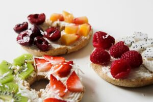 Gluten free bagels with fruit toppings on top of a white table