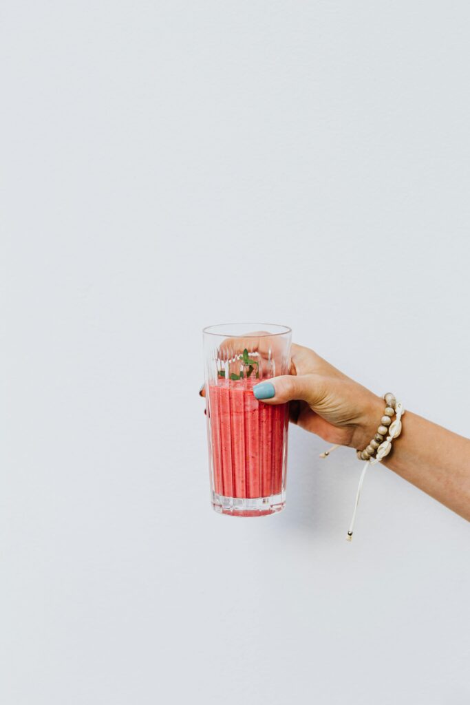 Woman Holding a Pink bahama mama Smoothie in a Glass