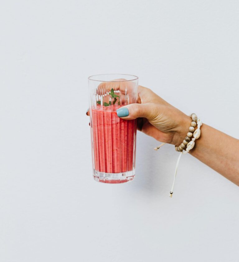 Woman Holding a Pink bahama mama Smoothie in a Glass